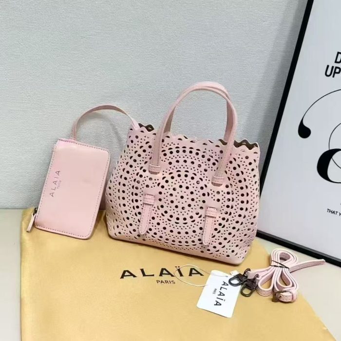 Alaïa Mina 20 tote bag in rose pink calf leather with a signature Vienne laser-cut motif and a removable pouch